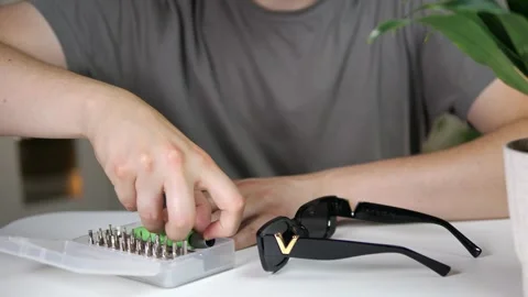 Close-up of hands methodically organizing tools for a repair task. The focus on Stock Footage 315496402