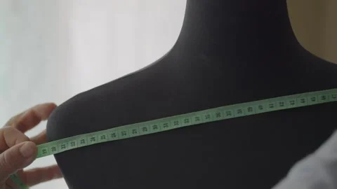 Close up on the hands of a middle-aged seamstress measuring textile Stock Footage 309203416