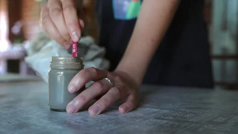 Close-up of hands mixing clay slip with a stick in slow motion Video stock 295889742
