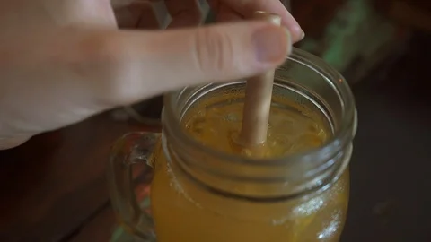 Close up Hands Mixing Cocktail Lemonade with Eco-Friendly Straw. Stock Footage 108626114