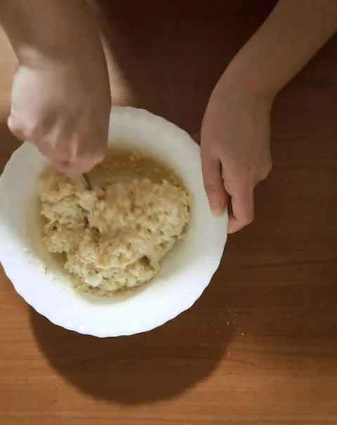 Close-up of hands mixing flour and fresh eggs in a bowl for dough preparation Stock Footage 329352289