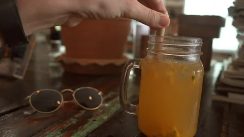 Close up Hands Mixing Passion Fruit Cocktail Lemonade with Eco-Friendly Straw. Stock Footage 108623195