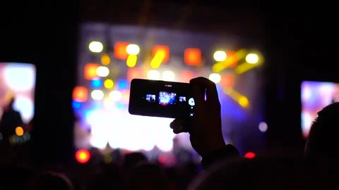 Close up of Hands with Mobile Phone Shooting Video and Taking Photo at Music Stock Footage 126973575