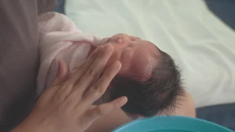 Close up hands of mother cleaning on newborn baby's face Stock Footage 274141663
