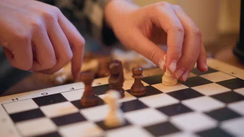 Close up of hands moving chess pieces on checkered board during gameplay with Stock-Footage 346730118