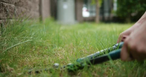 Close up hands mows grass, in backyard. Accurate lawn mowing, gardening concept. Stock Footage 249929203