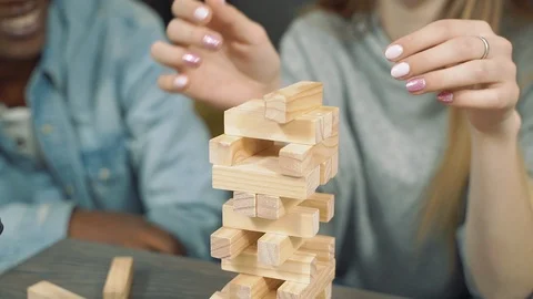Close up hands of multinational friends playing block removal game Stock Footage 124044594