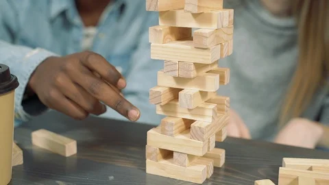 Close up hands of multinational friends playing block removal game Stock Footage 124044815