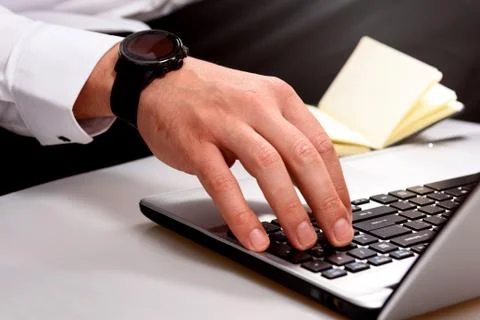 Close up hands multitasking man using laptop Foto stock