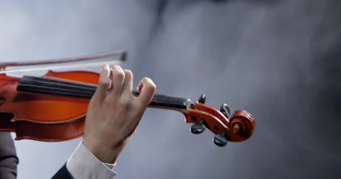 Close-up of the hands of a musician playing a classical violin against a Video stock 256876244
