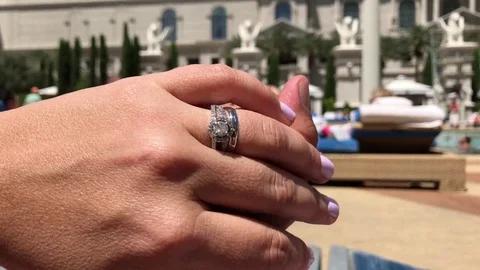 Close-up of hands of newlywed couple in front of a pool at resort. 動画素材 83183409