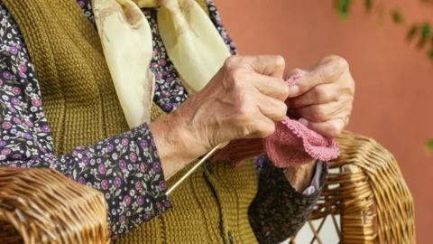 Close-up of a hands of old grandma knitting warm traditional Serbian socks Stock Footage 132390322