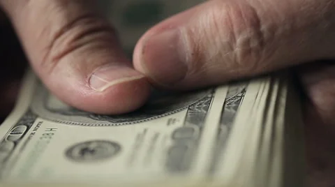 Close up of hands of an old man counting hundred dollar bills at a table Stock Footage