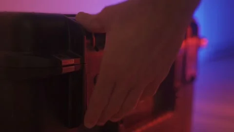 Close up - Hands open and close a hard black protective case red and blue BG Stock Footage 131897676