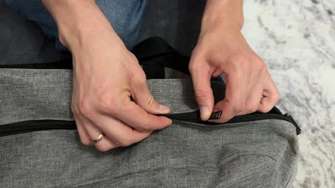 Close up hands opening and closing zipper on fabric bag at home. Everyday 스톡 동영상 336978876