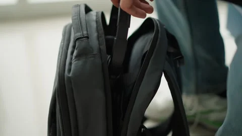 Close up of hands opening black fabric double backpack zippers to reveal Stock Footage 346651716