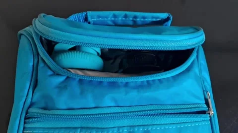 Close-up of hands opening a blue backpack zipper. Casual traveler or student Stockbeeldmateriaal 340480645