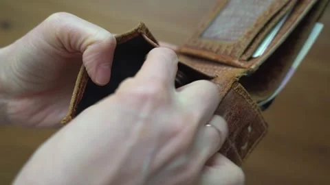 Close-up of hands opening a brown leather wallet, revealing an empty card slot Stock Footage 338172363