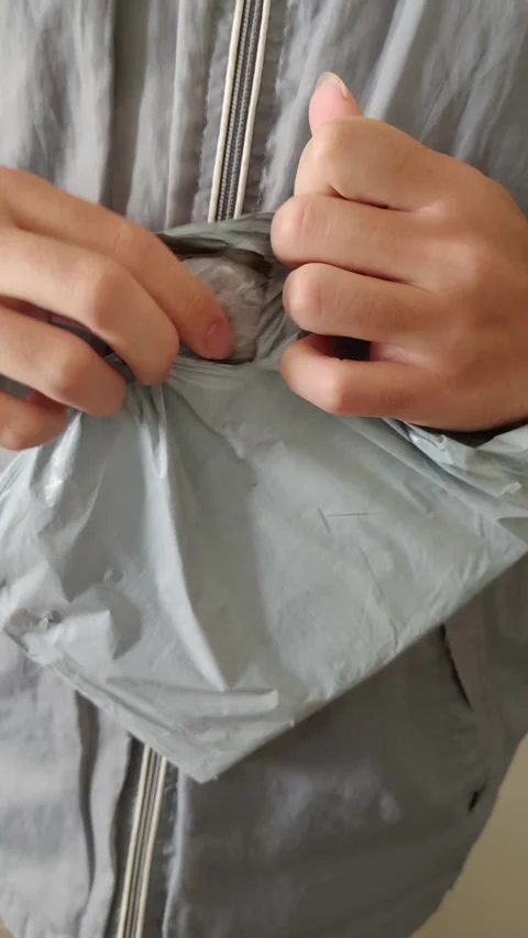 Close-up of hands opening gray mailer – unboxing, delivery, online shopping Stock Footage 312897750