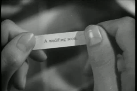 Close-up of hands opening note from fortune cookie Stock Footage 11353086