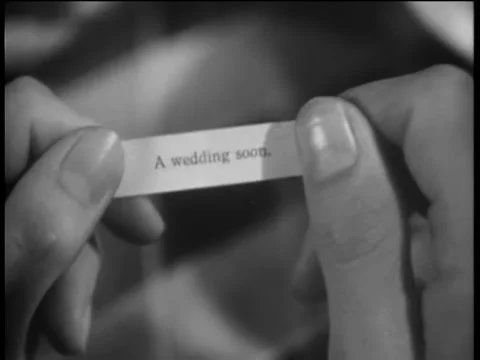 Close-up of hands opening note from fortune cookie - A Wedding Soon Stock Footage 260251152