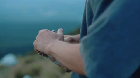 Close up hands opening an old tin box on a windy, overcast day on a mountin Stock Footage 121802188