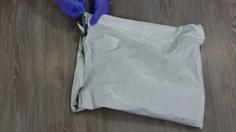 Close-up of hands opening a parcel delivery box with scissors. 库存影片 167854766