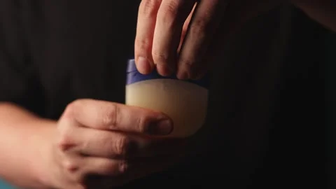 Close-up of hands opening a petroleum jelly jar for skin care Stock Footage 340267861