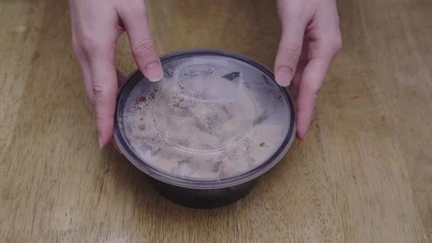 Close up of hands opening a plastic lid of a food delivery bowl with rice a.. Stock Footage 338400247