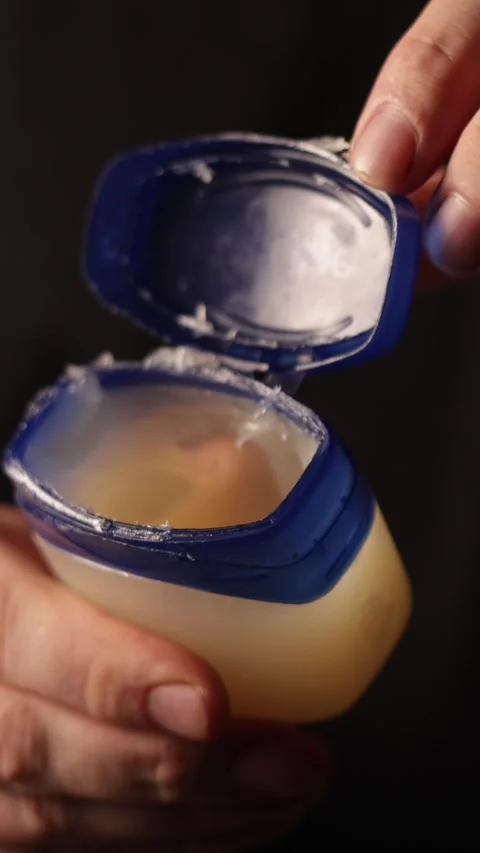 Close-up of hands opening a small petroleum jelly container for skin care Stock-Footage 343838057