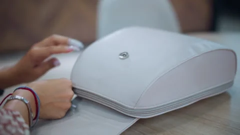 Close-Up of Hands Opening Stylish White Bag on Table Stock Footage 292830184