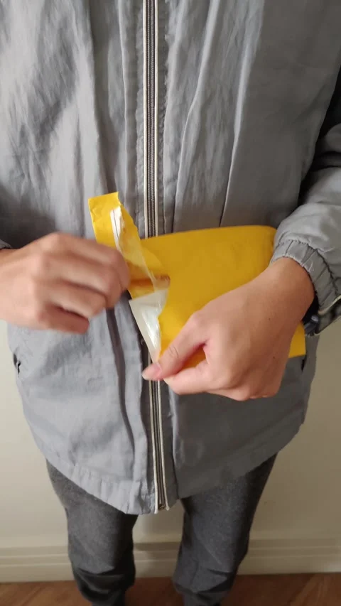 Close-up of hands opening a yellow padded mailer after delivery. Stock Footage 312897698
