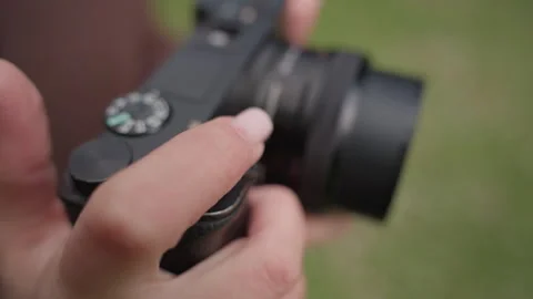 Close up of hands operating camera controls on black digital device with green Stock Footage 347100563