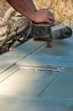 A close-up of hands operating a palm sander on wood Stock Photos