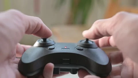 Close-up of hands operating a remote control for a toy helicopter, moving Video stock 319495092