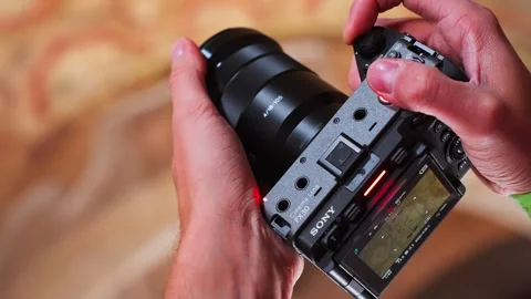 Close-up of hands operating a Sony FX30 with mounted lens, showing on-location 스톡 동영상 333895769