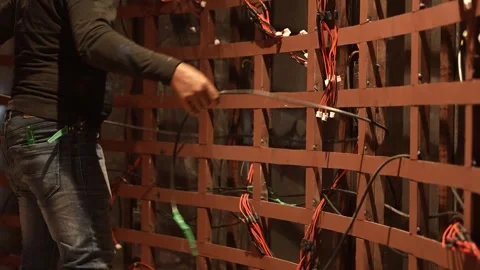 Close-up of hands organizing complex wiring on a metal frame. Stock-Footage 330240029