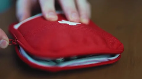Close up of hands packing and closing a red portable first aid kit pouch fu.. Vídeo Stock 340159751