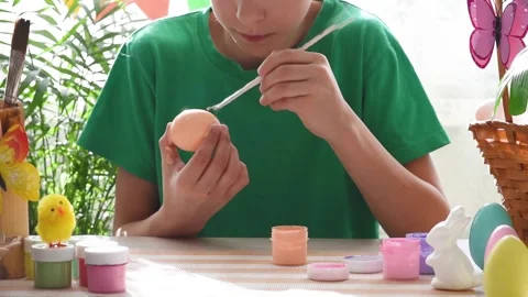 Close-up of hands painting a chicken egg orange. Stock Footage 175516127