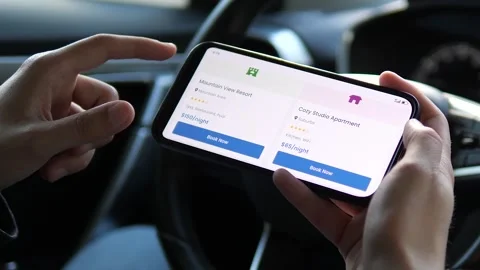 Close-up of hands pausing on a lodging reservation app, capturing the moment of Stock-Footage 316751548