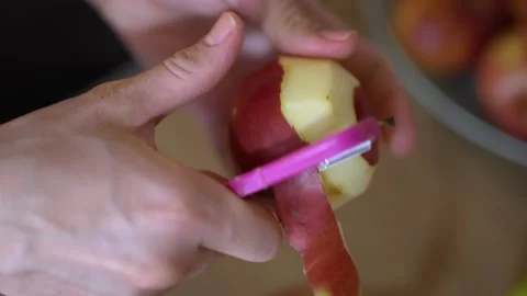 Close-up of hands peeling an apple. Woman's hands removes the skin of apple Stock Footage 235735890