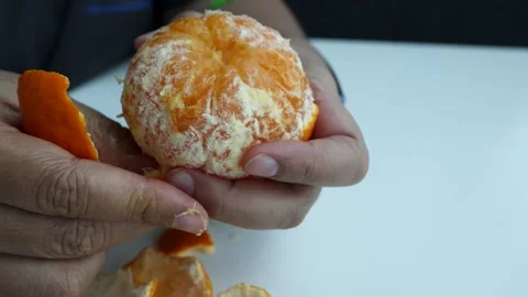 Close Up of Hands Peeling Fresh Mandarin Orange 스톡 동영상 347054090