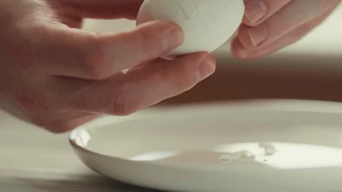 Close up of hands peeling a hard-boiled chicken egg. Stock Footage 330304873