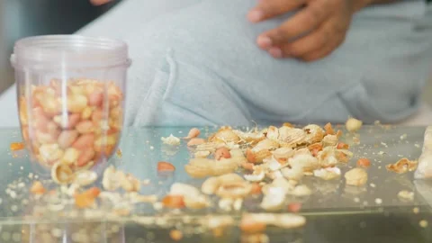 Close Up of Hands Peeling Raw Peanuts Over Glass Table Video stock 347141605