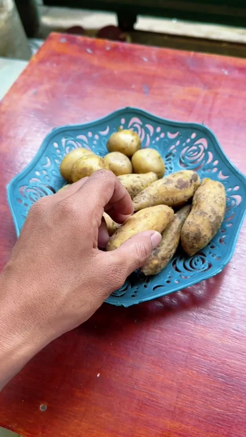 Close up of hands peeling skin off boiled yellow sweet potato Stock Footage 340049939