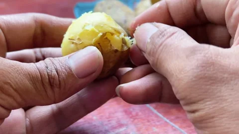 Close up of hands peeling skin off boiled yellow potato Stock Footage 340049985