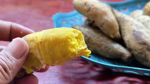 Close up of hands peeling skin off boiled yellow sweet potato Stock Footage 340049986