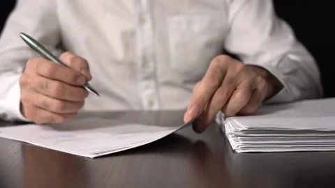 Close-up of Hands with Pen on Paper Documents Sitting Stock Footage 156935567