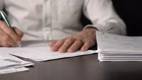 Close-up of Hands with Pen on Paper Documents Sitting Stock Footage 166997016