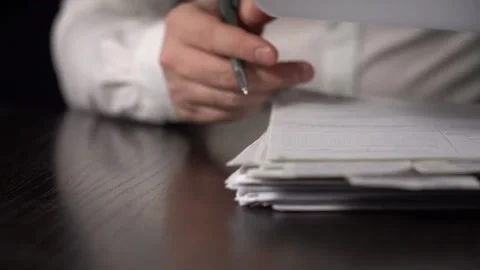 Close-up of Hands with Pen on Paper Documents Sitting Stock Footage 167214486